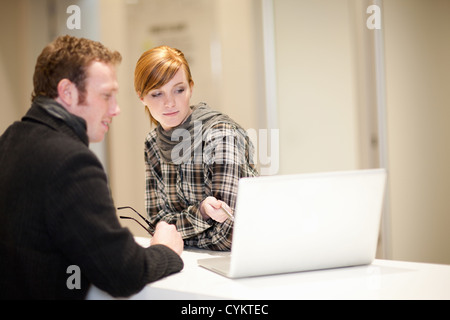 Geschäftsleute, die mit Laptop im Büro Stockfoto