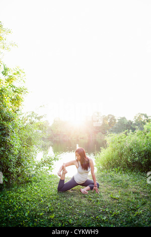 Frau praktizieren Yoga im Garten Stockfoto