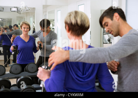 Trainer, die Anpassung der Frau Form im Fitness-Studio Stockfoto