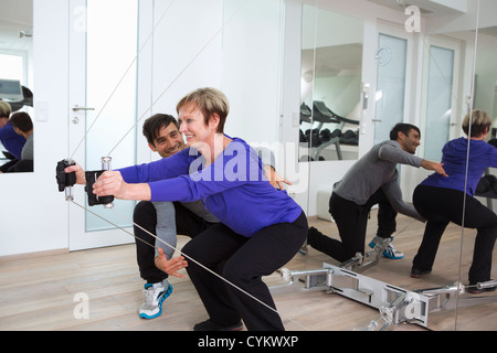 Trainer, die Anpassung der Frau Form im Fitness-Studio Stockfoto