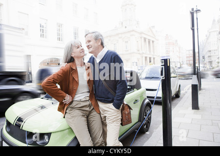 Paar Aufladen von Elektroautos auf die Straße Stockfoto