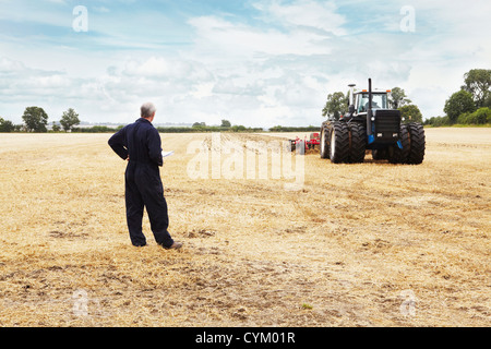 Mit Blick auf Traktor Farmer Ernte Feld Stockfoto