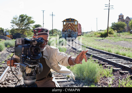 Afrikanische Amerikaner mit Film-Kamera in der Nähe von Eisenbahnschienen Stockfoto