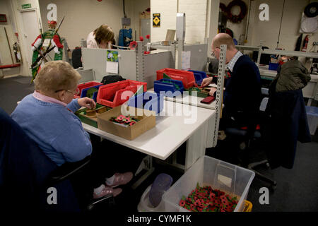 7. November 2012. London UK.  Arbeiter in der Mohn Fabrik befindet sich in Surrey, feiert 90 Jahre Mohn Kränze zu machen und für die Royal British Legion Erinnerung Beschwerde kreuzt. Da die Mohn Fabrik Verwundeten Platzierung wurde hat 2007 Veteranen Krieg und ex-Militärs in Arbeitsplätze rund um das Vereinigte Königreich. Stockfoto