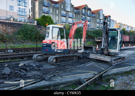 Zwei kleine Traktor Bagger abgestellt in kleinem Maßstab Spur Reparaturen in Bristol alte Stadt Zentrum Docklands verwendet. Stockfoto