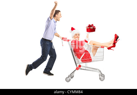Glücklicher Kerl schob ein Weibchen mit Geschenk in einem Einkaufswagen isoliert auf weißem Hintergrund Stockfoto