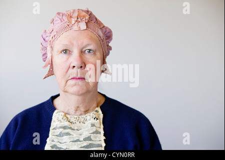 Mürrischen senior Frau im Studio mit einem Vintage Hut und Spitze. Stockfoto