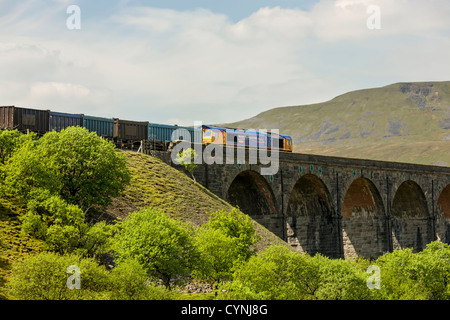 Class 66 Deisel e-Lok zieht einen Güterzug über Ribblehead-Viadukt, North Yorkshire Stockfoto