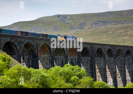 Class 66 Deisel e-Lok zieht einen Güterzug über Ribblehead-Viadukt, North Yorkshire Stockfoto