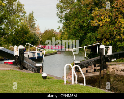 Schmalen roten Boot nähert sich eine Sperre auf dem Union-Kanal bei Marsworth, Buckinghamshire, Großbritannien Stockfoto