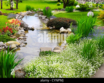 Frühlingsblumen im asiatischen Garten mit einem Teich Stockfoto