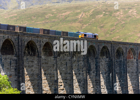 Class 66 Deisel e-Lok zieht einen Güterzug über Ribblehead-Viadukt, North Yorkshire Stockfoto