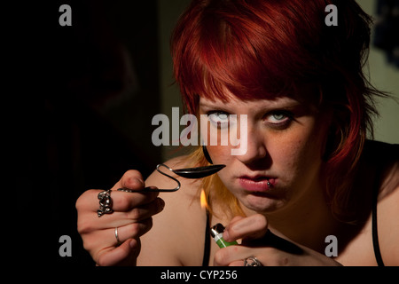 Junge Frau, die kochen Heroin in einem gebogenen Löffel Stockfoto