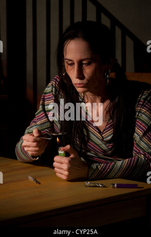 Frau Kochen Heroin in einem gebogenen Löffel Stockfoto