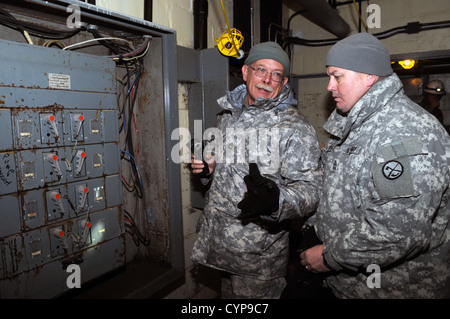 Sgt. 1. Klasse Marty Newman, von der W.VA Army National Guard 3664th Wartungsfirma, beschreibt das Ausmaß der Schäden von Schalttafeln im Keller einer Brooklyn Apartmentanlage, die während Hurrikan Sandy mit Master Sgt. Ryan Power überflutet Stockfoto