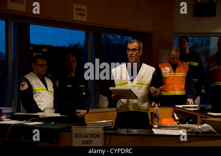 NEW YORK – Ed Primeau, eine Sicherheitsfachkraft mit Coast Guard Atlantic Strike Team, verleiht eine Sicherheit kurze Responder beim Hurricane Sandy Verschmutzung Antwort Unified-Befehl in Staten Island, New York, 7. November 2012. Während seiner kurzen erinnert Primeau Responder Stockfoto