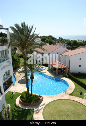 Calahonda, Cost del Sol, Spanien. Blick vom Balkon einer Wohnung in Calahonda, mit Blick auf eine Palme, gepflegten Pool und das Meer Stockfoto