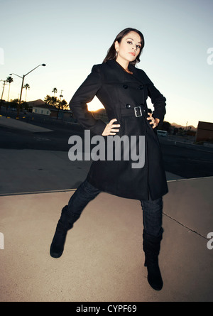 Schöne Frau Iwearing schwarzen Trenchcoat bei Sonnenuntergang Stockfoto