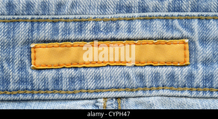 Leere gelbe Textil-Label aufgenäht eine blaue Jeans. Dient als Hintergrund für Ihren Text. Stockfoto