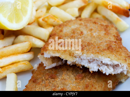 Fish And Chips mit Zitrone auf einem weißen Keramik Teller Stockfoto