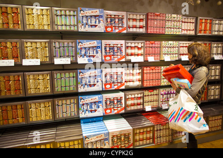 Eine Dame betrachtet man Kisten mit Christmas Cracker in John Lewis Department Store Weihnachtsshop, London, England, Vereinigtes Königreich Stockfoto