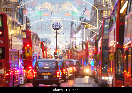 Weihnachtsbeleuchtung während der Hauptverkehrszeit in der Abenddämmerung auf der geschäftigen Oxford Street, Oxford Circus, West End, London, England, Vereinigtes Königreich Stockfoto