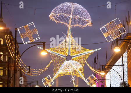 Weihnachtsbeleuchtung während der Hauptverkehrszeit in der Abenddämmerung auf der geschäftigen Oxford Street, Oxford Circus, West End, London, England, Vereinigtes Königreich Stockfoto