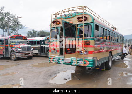 Laden Huhn Busse hinter dem Mercado Municipal (Stadtmarkt) in Antigua, Guatemala. Aus diesem umfangreichen zentralen Busbahnhof strahlenförmig der Routen in Guatemala. Oft bunt bemalt, die Huhn-Busse sind nachgerüsteten amerikanische Schulbusse und bieten ein günstiges Transportmittel im ganzen Land. Stockfoto