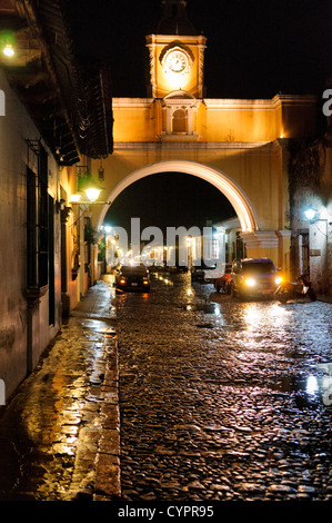 Der Torbogen über die Straße des Klosters Santa Catalina in zentralen Antigua, Guatemala, mit dem Wasser aus den letzten Regen reflektieren das Licht auf der Straße mit Kopfsteinpflaster. Stockfoto