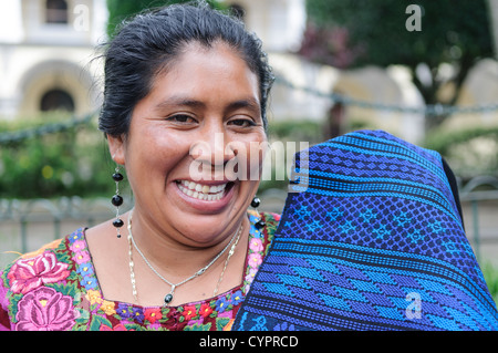 ANTIGUA GUATEMALA, Guatemala – Clara, eine einheimische Weberin, die ihre gewebten Textilien im Parque Central in Antigua, Guatemala verkauft. Stockfoto