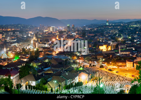 Abenddämmerung Ansicht von Sarajevo, das Kapital Stadt von Bosnien und Herzegowina. Im Vordergrund steht die Märtyrer Gedenkfriedhof Kovaci. Stockfoto