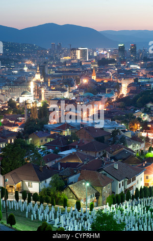 Abenddämmerung Ansicht von Sarajevo, das Kapital Stadt von Bosnien und Herzegowina. Im Vordergrund steht die Märtyrer Gedenkfriedhof Kovaci. Stockfoto