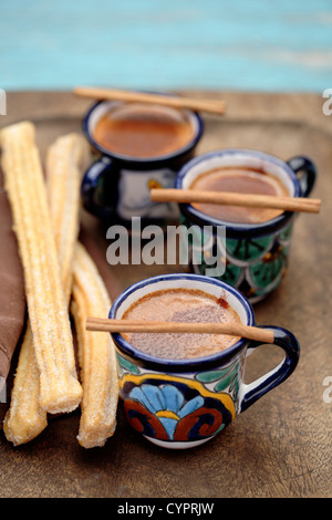 Mexikanische heiße Schokolade mit Zimtstangen und churros Stockfoto