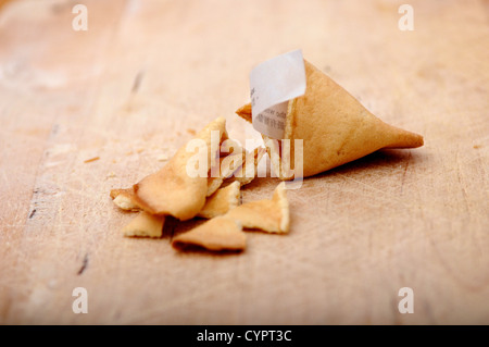 Gebrochenen offenen chinesischen Glückskeks auf ein Schneidbrett aus Holz Stockfoto