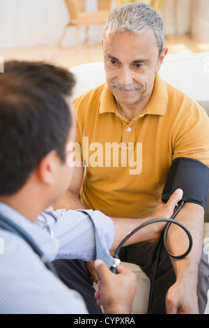 Hispanic Mann mit seinen Blutdruck Stockfoto