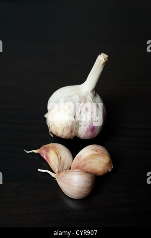 Zopf von Knoblauch Zwiebeln Nahaufnahme auf schwarzem Hintergrund Stockfoto