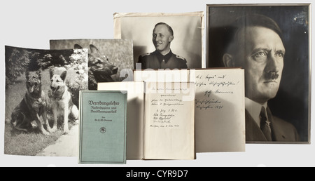 Fritz Darges,Fotografien und Bücher großformatige Porträtfotografie (ca. 33 x 23.5 cm),Darges in Uniform als Untersturmführer des SS-Regiments 'Deutschland'(ca. 1940),das beschädigte Passepartout mit Unterschrift des Fotografen 'Jäger Berlin'. Großes Porträtfoto (ca. 40 x 30 cm) von Hitler in Zivil (gefleckt), in einem späteren Rahmen. Zwei großformatige Fotografien (ca. 30 x 24.5 cm/spätere Drucke?) von Hitlers deutschen Schäfern um 1934, Muck und Blondi und Muck mit einem Rehkitz, wahrscheinlich aus der gleichen Serie wie die Hoffman-Postkarte 'der Führer als T, Additional-Rights-Clearences-not available Stockfoto