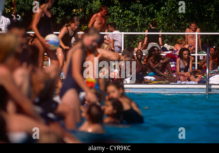 Ein multi-ethnisches Publikum genießt eine Hitzewelle in Herne Hill Lido, Süd-London, England. Stockfoto