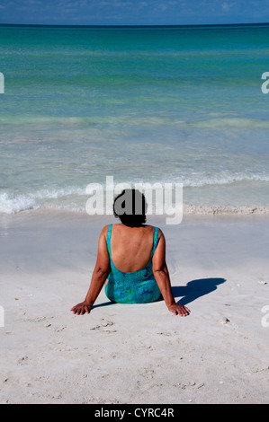 Ältere Frau entspannend am tropischen Strand Stockfoto