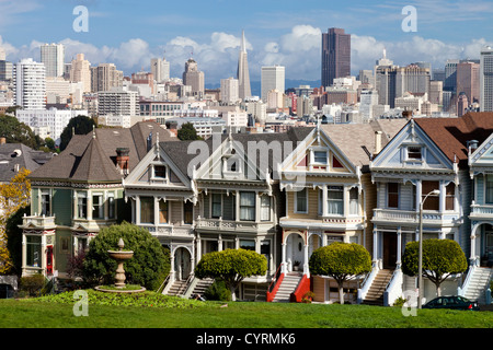 Painted Ladies mit Skyline von San Francisco im Hintergrund von Alamo Square gesehen. Stockfoto