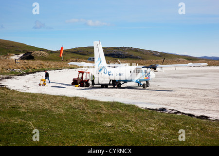 Passagiere aussteigen und Gepäck entladen von Flybe Flug Traigh Mhor, Barra, äußeren Hebriden, Schottland, UK Stockfoto