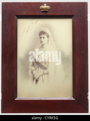 Portraitfoto von Tsarina Alexandra Feodorowna, mit handschriftlicher Unterschrift in Tinte Russland, ca. 1900. Der rechte Rand mit Prägung des Hoffotografen 'A. Pasetti". In Gold auf der Rückseite der Name des Fotografen mit mehreren Medaillen abgedruckt. Leicht gefleckt. Unter Glas, in braun lackiertem Holzrahmen, wurde die Oberseite mit einer goldbronzierten Kaiserkrone aus Messing aufgetragen. Der Rahmenständer hinten fehlt. Bild CA. 21,6 x 15 cm, Rahmen 30,3 x 23,5 cm. Alexander Ivanovich Pasetti studierte an der Sankt Petersburger Kunsthochschule und gewann dort im Jahr 1872 Silbermedaillen und Stockfoto