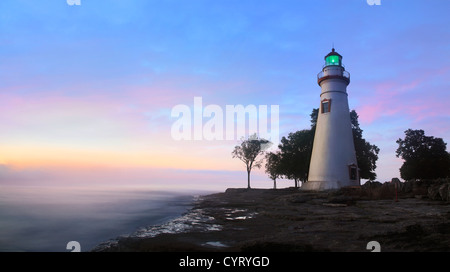 Die Marblehead Leuchtturm strahlt es Grünlicht, wie die Sonne wärmt den östlichen Himmel initiieren einen neuen Tag in Marblehead Oh Stockfoto