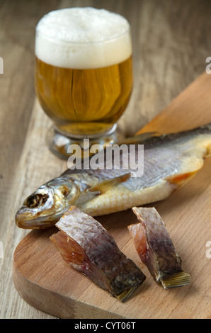 Salz, getrockneter Fisch und ein Glas Bier auf hölzernen Hintergrund Stockfoto