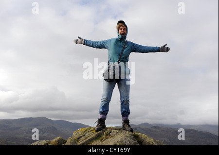 Ansichten rund um Loughrigg fiel in der Nähe von Ambleside Seenplatte Frau in unmittelbarer Stiefel Aufstieg auf den Gipfel auf Herbsttag Stockfoto