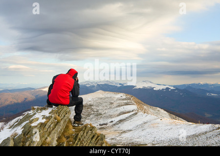 Einsamen Bergsteiger auf dem Gipfel eines Berges Stockfoto