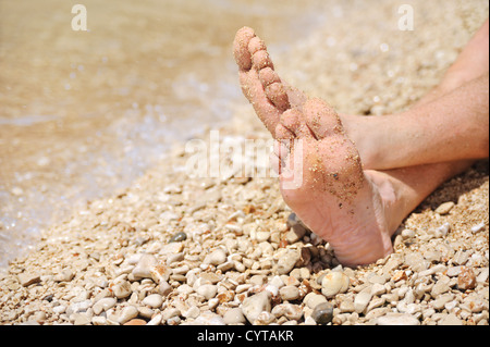 Entspannung am Strand, Detail der männliche Füße Stockfoto