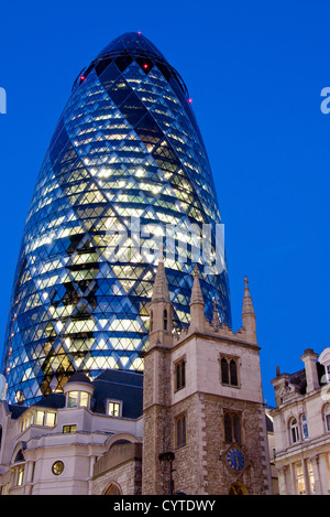 Swiss Re Gebäude 30 St Mary Axe auch bekannt als die Gurke in der Nacht mit Turm von St. Andrew Undershaft Stadt von London England UK Stockfoto