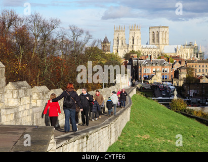 Menschen zu Fuß entlang York Stadtmauer mit York Minster im Hintergrund nördlichen England UK Stockfoto