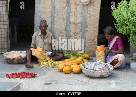 Alte indische paar schälen und schneiden Papaya außerhalb ihrer ländlichen indischen Heimat. Andhra Pradesh, Indien Stockfoto